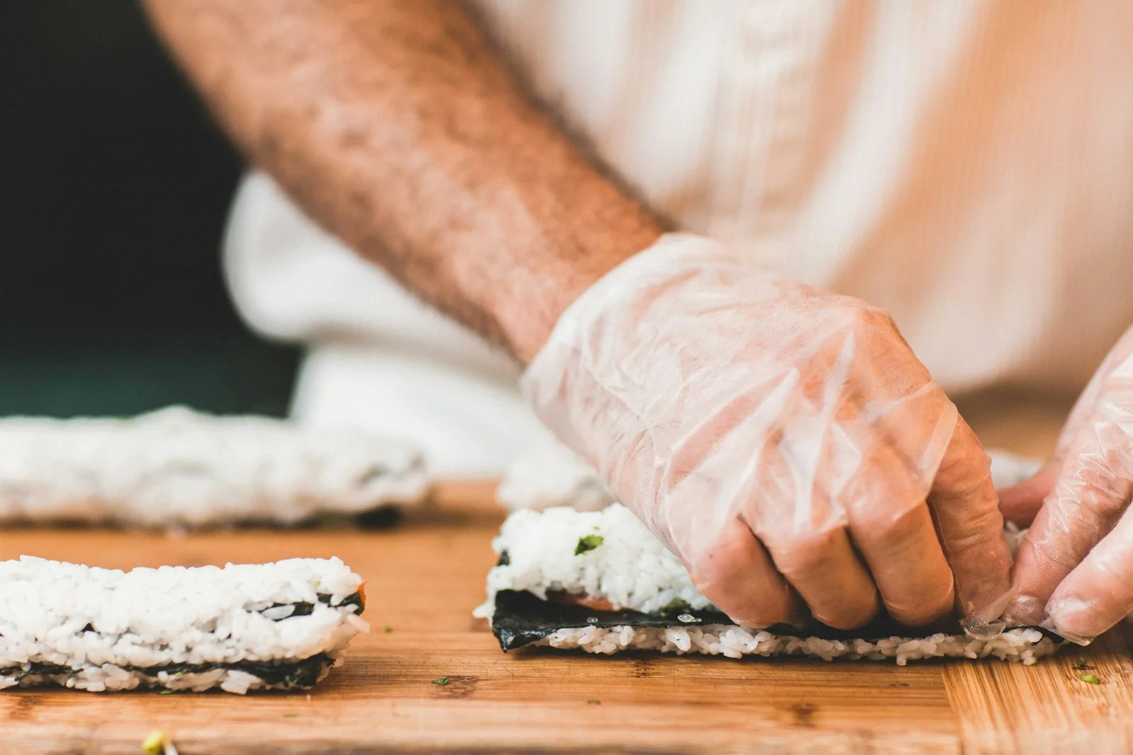 A chef's hands preparing sushi by hand