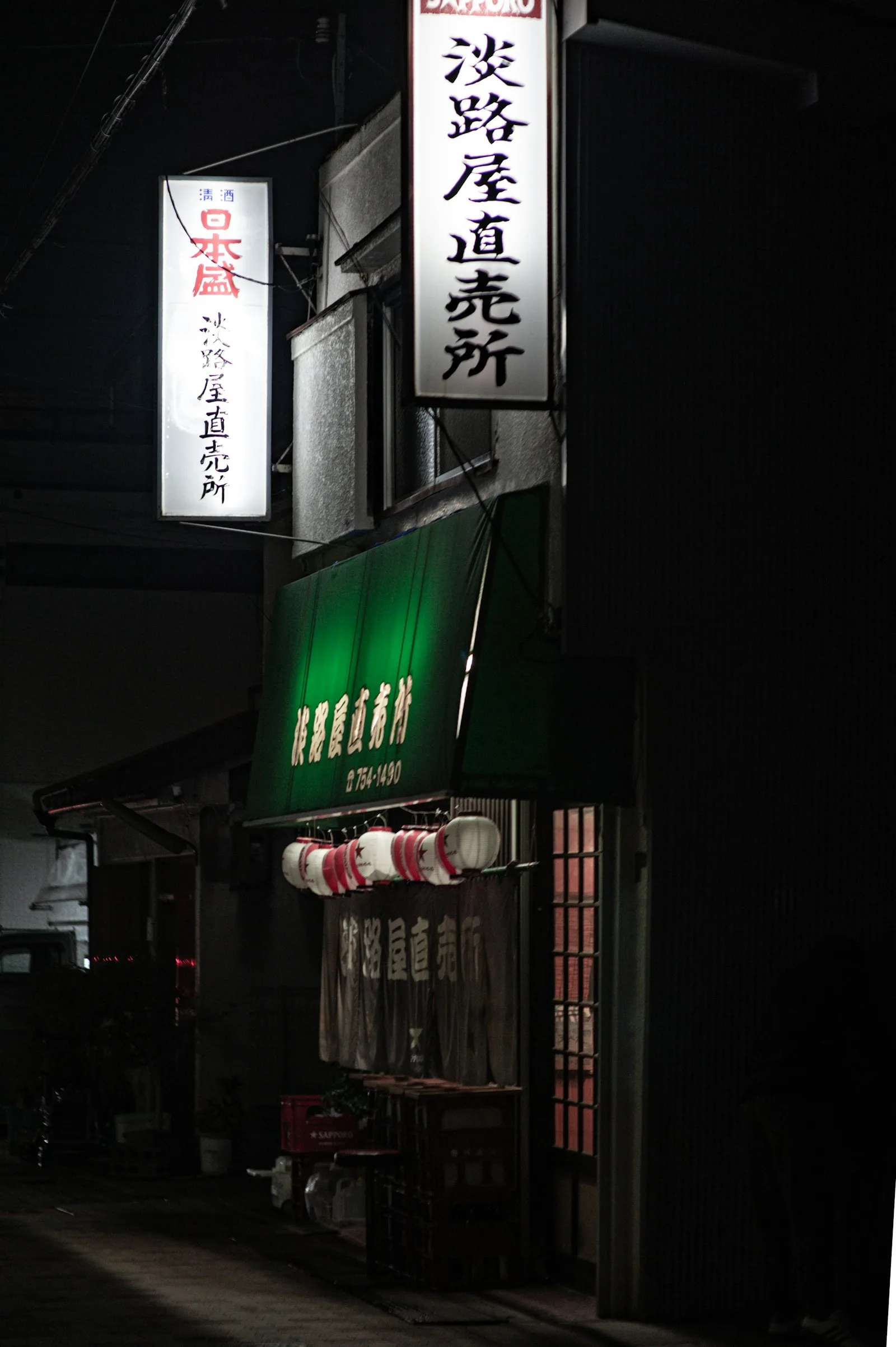Japanese restaurant storefront lit up with lanterns at night
